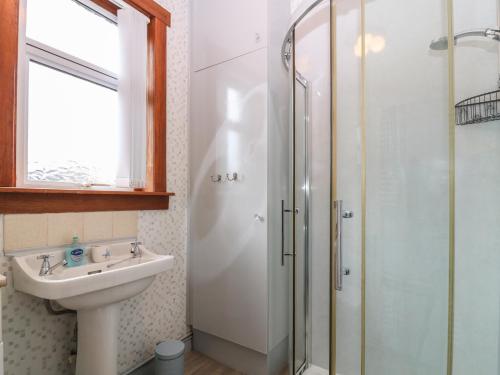 uma casa de banho com um lavatório e um chuveiro em Thain House em Banff
