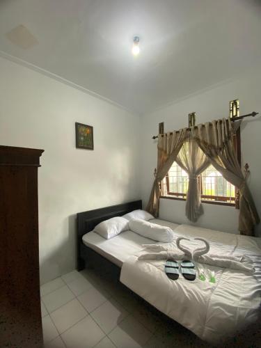 a bedroom with two beds and a window at Griya Indah Homestay in Pacet