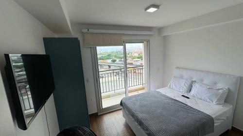 a bedroom with a bed and a large window at HM - Aconchegante Apto em Santana in São Paulo