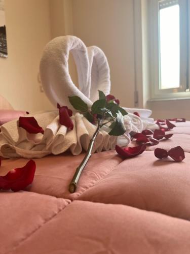 a flower on a bed with a towel and a swan at Palazzo Sant'Antonio in Rome