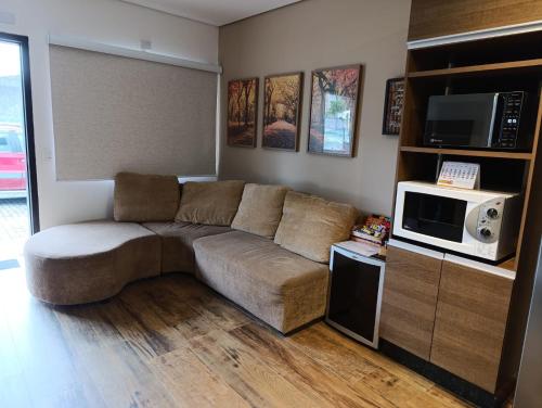 salon z kanapą i kuchenką mikrofalową w obiekcie Residencial Luce Del Sole - Casa Nº 5 w mieście Joinville