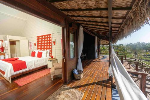 Un dormitorio con una cama y una hamaca en una terraza. en Baía das Caraúbas, en Camocim