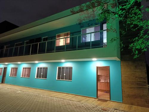 a blue and green building with a door at night at Residencial Luce Del Sole - Casa Nº 5 in Joinville
