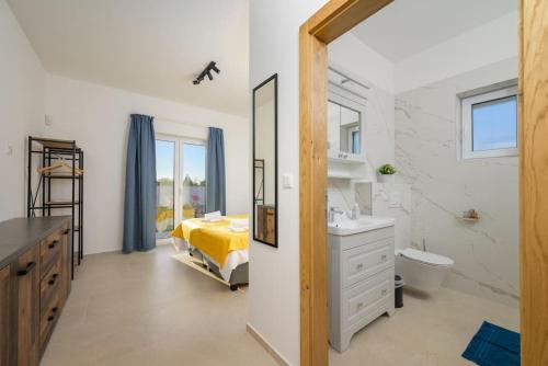 een badkamer met een bed, een wastafel en een spiegel bij Villa Martina by IstriaLux in Juršići