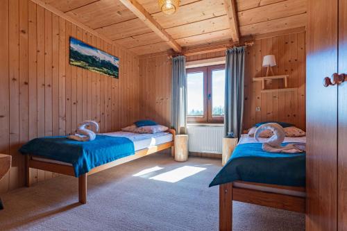 - une chambre avec 2 lits dans une maison en bois dans l'établissement Apartament GóralSki z widokiem na tatry, à Brzegi