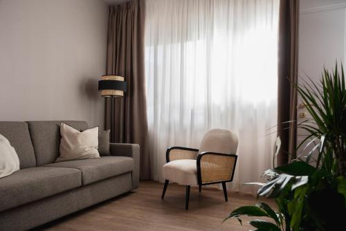 a living room with a couch and a chair and a window at Garden Suites in Rome