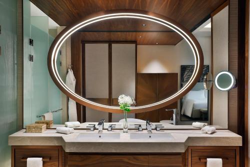 a bathroom with a sink with a large mirror at Conrad Rabat Arzana in Rabat