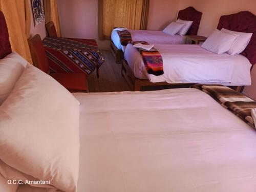 a hotel room with three beds with white sheets at Allpa Tika Lodge in Ocosuyo