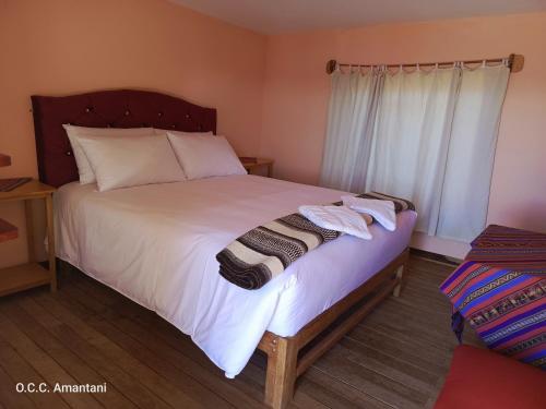 a bedroom with a large bed with two towels on it at Allpa Tika Lodge in Ocosuyo