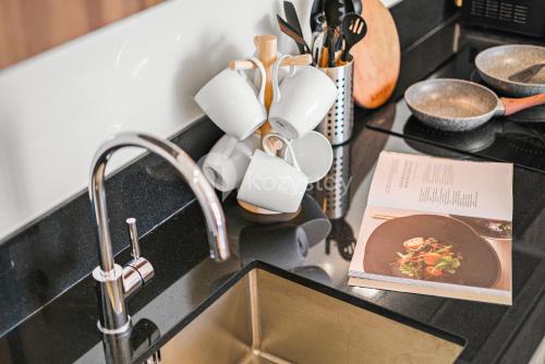 a kitchen counter with a sink and a book at Rhone by Kozystay - Thamrin in Jakarta