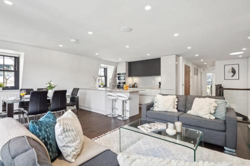 a living room with a couch and a table at 3BR Penthouse with Terrace - CityApartmentStay in London