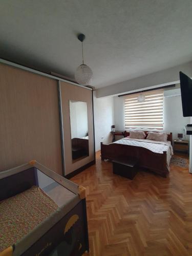 una camera da letto con un letto e un grande specchio di Apartment Idea a Novi Pazar