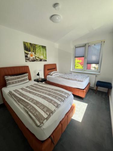 2 Betten in einem Zimmer mit 2 Fenstern in der Unterkunft Ferienhaus Cassel in Kassel