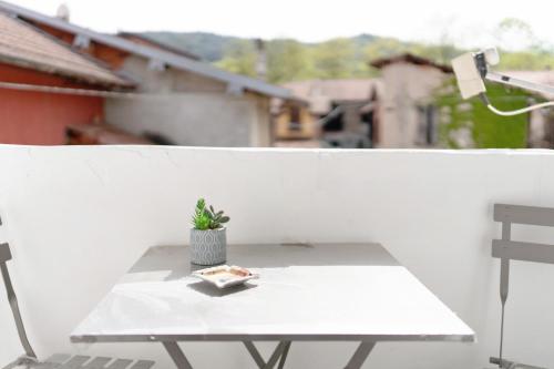 a white table with a potted plant on a balcony at Casa Perry - Lago Maggiore in Borgo Ticino