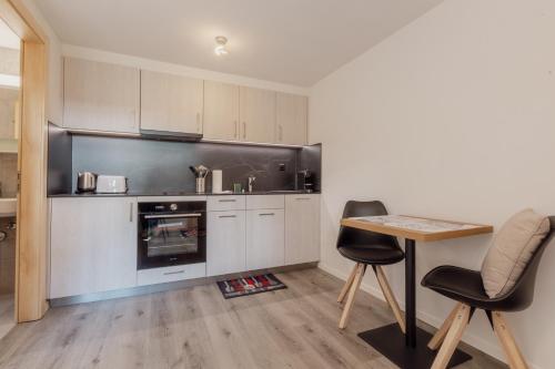 a kitchen with white cabinets and a table and chairs at Charmant studio rénové à Grimentz in Grimentz