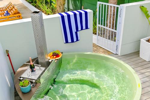 a jacuzzi tub on a deck in a backyard at Spray Villa Bloubergstrand with hot tub and close to the beach in Bloubergstrand