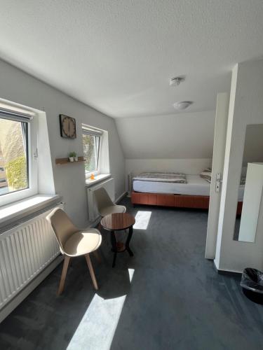 Habitación pequeña con cama, mesa y sillas en Ferienhaus Cassel en Kassel