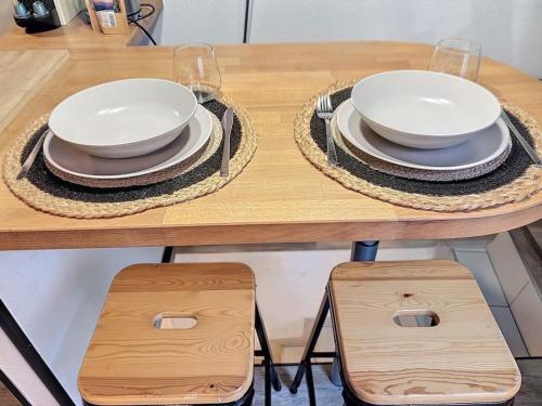 une table avec des assiettes et des verres au-dessus dans l'établissement Le Petit Ramblas - Charmant studio en Hypercentre, à Toulouse