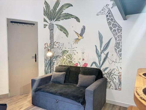 - un salon avec un canapé bleu en face d'un mur dans l'établissement Le Petit Ramblas - Charmant studio en Hypercentre, à Toulouse