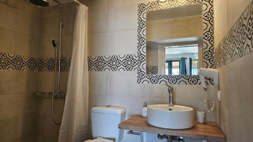 La salle de bains est pourvue d'un lavabo, d'un miroir et de toilettes. dans l'établissement Akteon Rooms, à Agia Galini