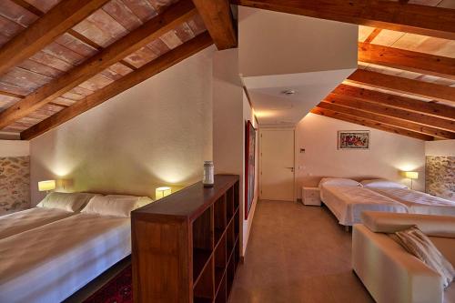 two beds in a room with wooden ceilings at Ca' n Beia Suites - Adults Only in Alaró