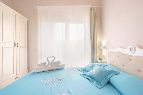 a bedroom with a bed with two swans on it at La rosa dei venti in Villasimius