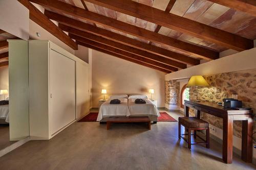 a large bedroom with a bed and a desk at Ca' n Beia Suites - Adults Only in Alaró