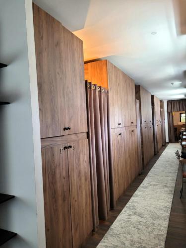 uma fila de cacifos de madeira num corredor em Elite Capsule Hotel em Balkhash