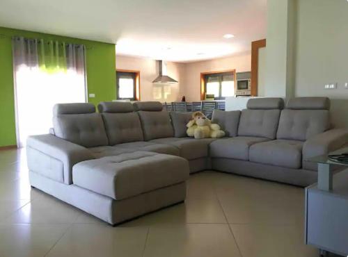 sala de estar con sofá grande y osito de peluche en Refúgio Sereno, Casa na Montanha com Piscina Privativa, en Braga
