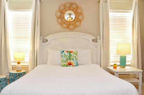 a bedroom with a white bed and two windows at The Palms 2B by Pristine Property Vacation Rentals in Mexico Beach