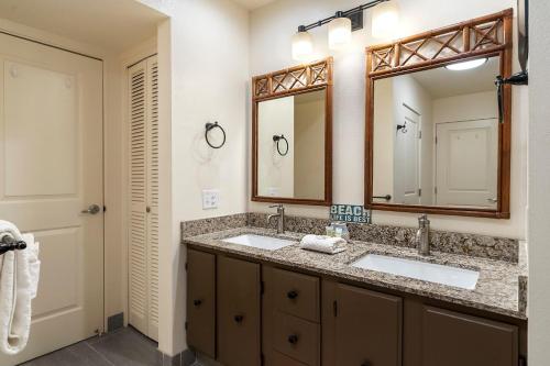 a bathroom with two sinks and a large mirror at Casa De Emdeko 324 in Kailua-Kona