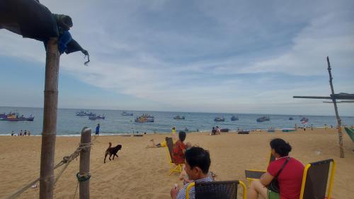 een groep mensen die in stoelen op het strand zitten bij Homestay Bọt Biển in Phú Hiệp