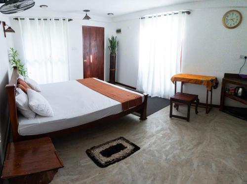 1 dormitorio con 1 cama, 1 mesa y 1 silla en Gypsy Garden Guesthouse & Homestay, en Kosgoda