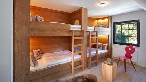 Cette chambre dispose de lits superposés avec 2 lits superposés. dans l'établissement LA MAISON Titisee - Boutique Design Villa im Schwarzwald, à Titisee-Neustadt