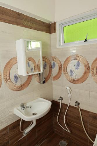 a bathroom with a sink and a mirror at Marvel Homestay in Yercaud