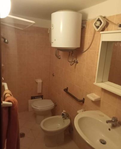 een badkamer met een toilet, een wastafel en een spiegel bij VistaMare &smeralda in Formia