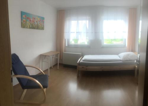 a room with a bed and a chair and a window at Ferienwohnung "Zwei Birken" in Ellwangen