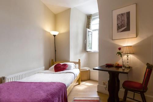 a bedroom with a bed and a table and a chair at City London Hotel in London