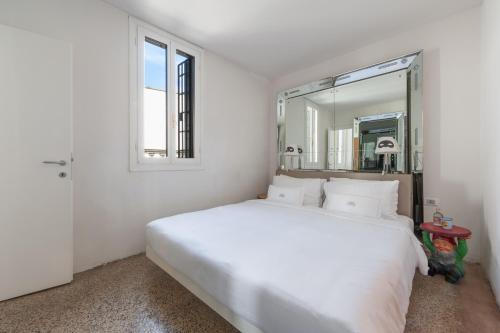a white bedroom with a large bed and a mirror at G House in Venice
