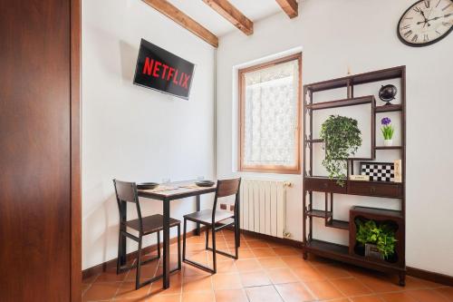 ein Esszimmer mit einem Tisch, Stühlen und einer Uhr in der Unterkunft Il Lusso Della Semplicità in Piacenza