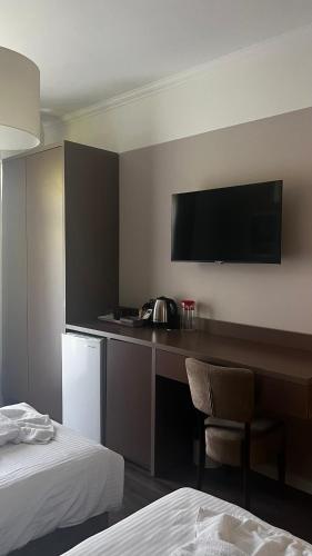 a hotel room with a desk and a television on the wall at Карпати Кайзервальд апарт in Karpaty
