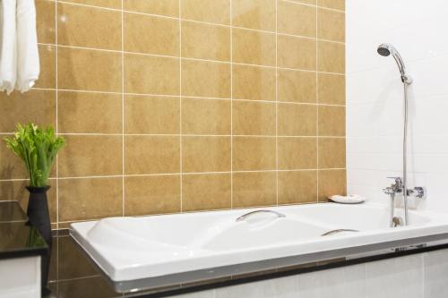 a bathroom with a sink and a tub at Tolani Nimman Villa Chiang Mai in Chiang Mai
