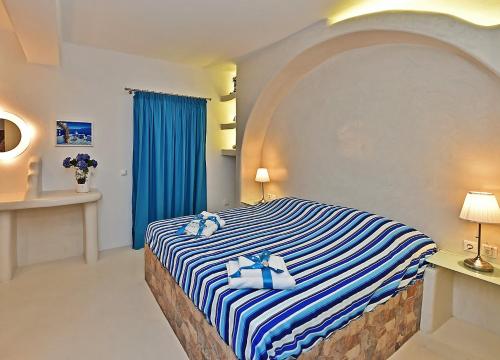 a bedroom with a bed with blue and white stripes at TINOS AQUA PALAZZO in Tinos Town