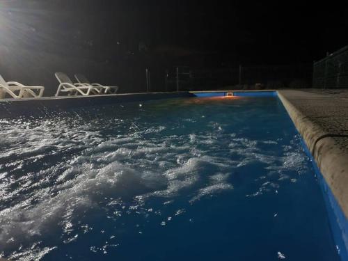 una piscina notturna con sedie e terra di Cabaña Cerro Tulahuén a Piedra Lisa