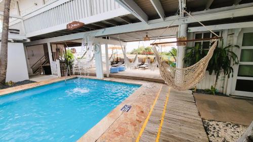 a swimming pool with a hammock and a house at La Jamaca - An Island Vibe Hotel in La Parguera