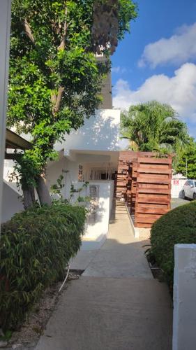 a white building with a tree and a sidewalk at La Jamaca - An Island Vibe Hotel in La Parguera