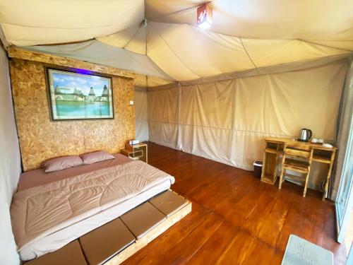 Pengalongan的住宿－Buana Glamping，一间帐篷内的卧室,配有一张床和一张书桌