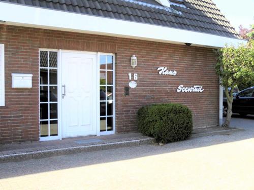 a brick building with a white door on it at BUE Appartementhaus Seewind in Büsum