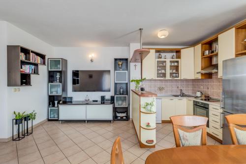 a kitchen with white cabinets and a table and chairs at Apartment Krilo Jesenice in Krilo