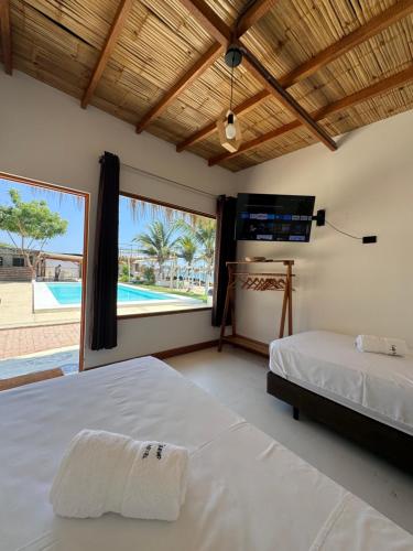 1 dormitorio con 2 camas y ventana grande en Costa Nueva en Zorritos